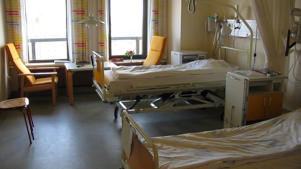 Dvoulůžkový pokoj s polohovacími postelemi a křesly u okna