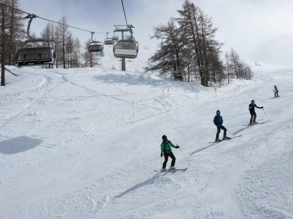 Lyžaři na sjezdovce pod sedačkovou lanovkou