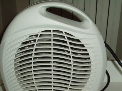 Elektrický teplovzdušný ventilátor s mřížkou a přívodním kabelem