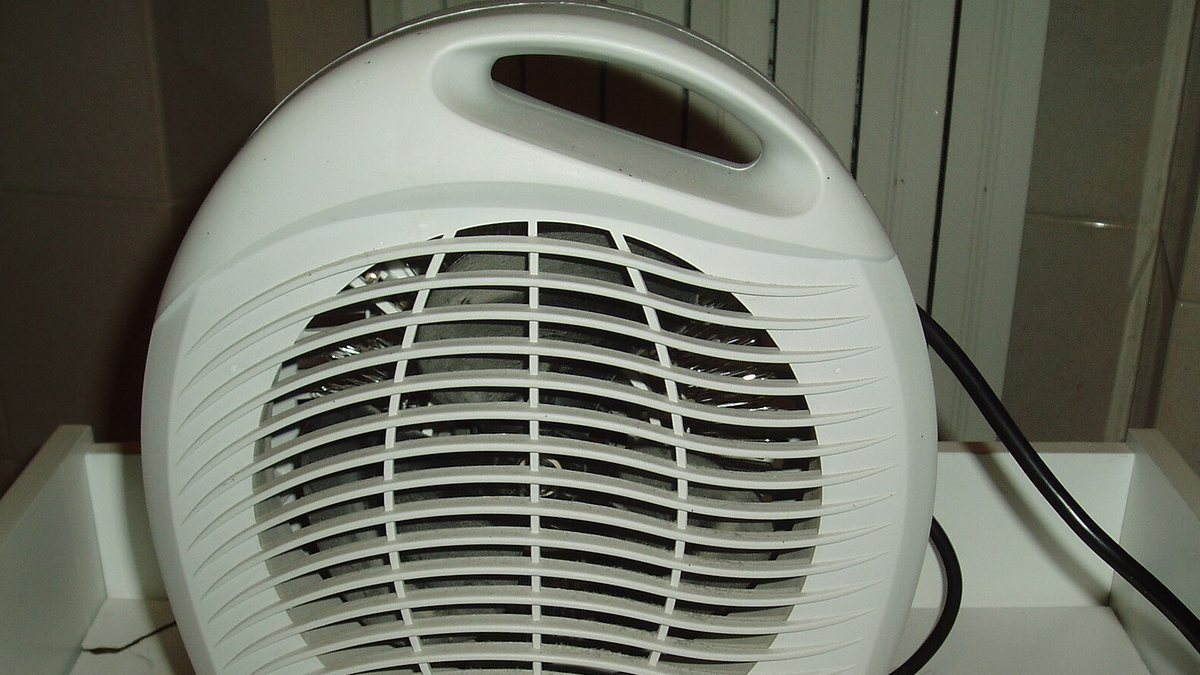 Elektrický teplovzdušný ventilátor s mřížkou a přívodním kabelem